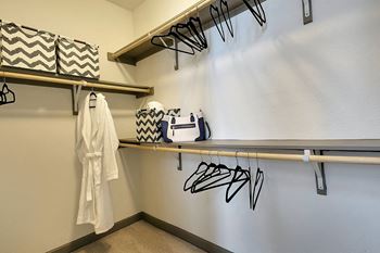Large closet with hangers, a bathrobe and some storage boxes at McKinney Village, Texas, 75069